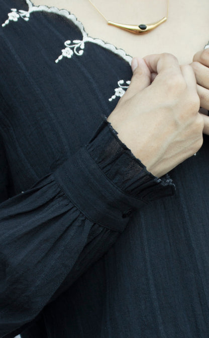 Detail picture of the sleeves of black embroidered top