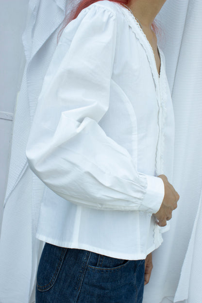 Side picture of white puff sleeve blouse with lace trim detail