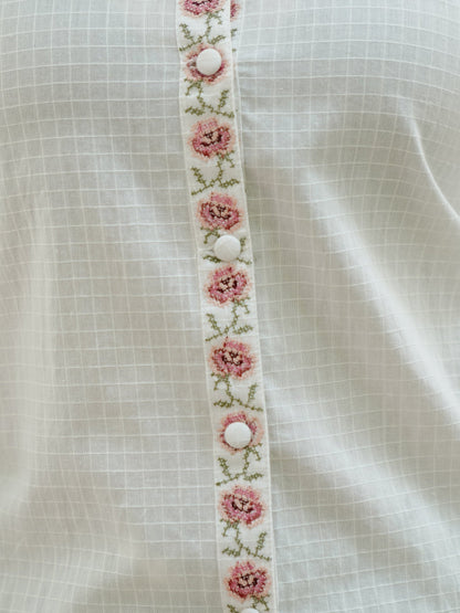 Detail picture of embroidery on white embrodiered button down top