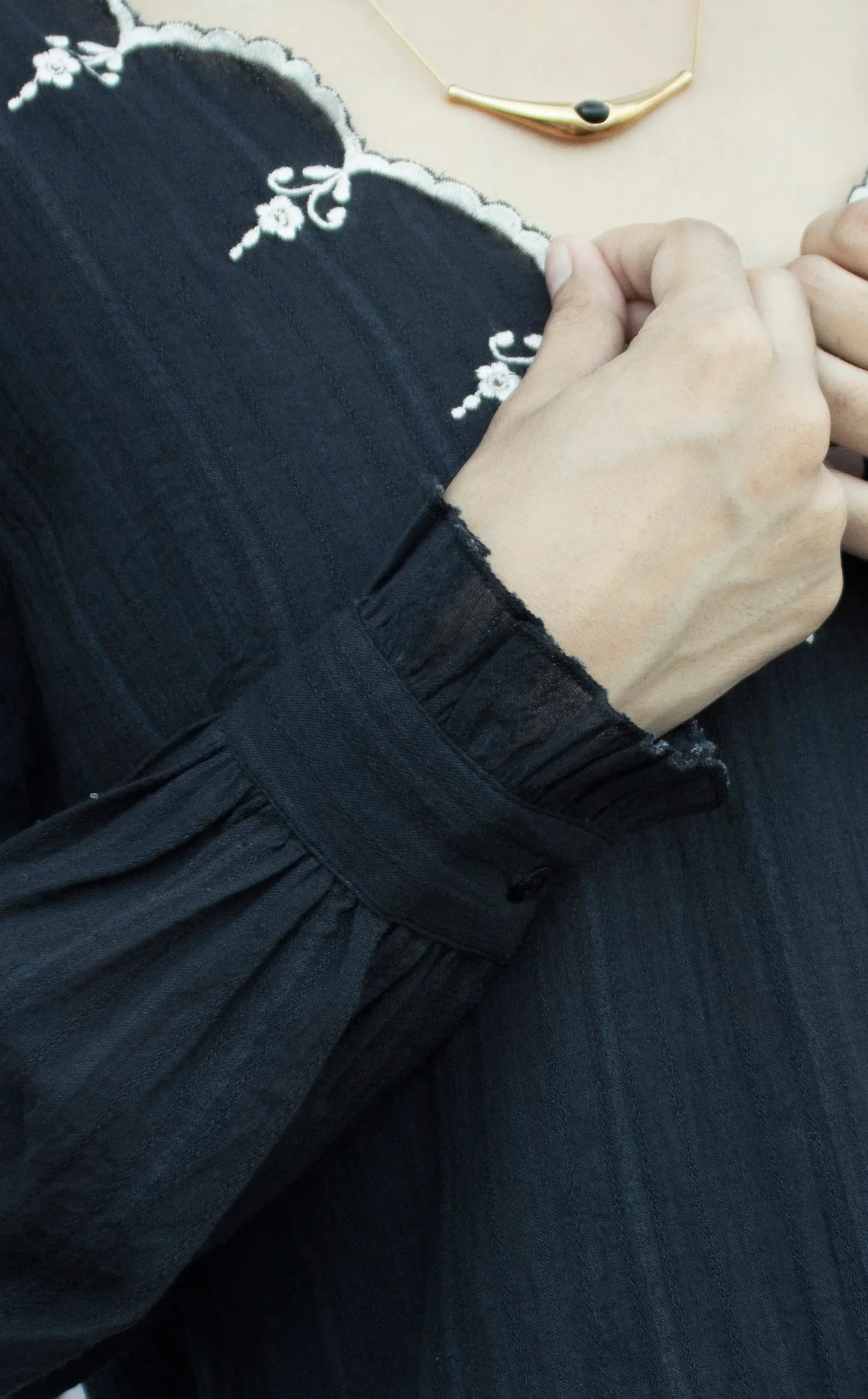 Detail picture of the sleeves of black embroidered top