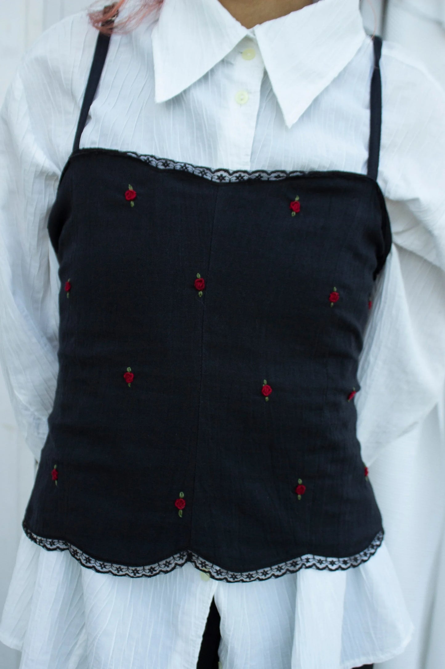 Front picture of black embroidered camisole showing red rose embroidery and scallop hem with lace detail