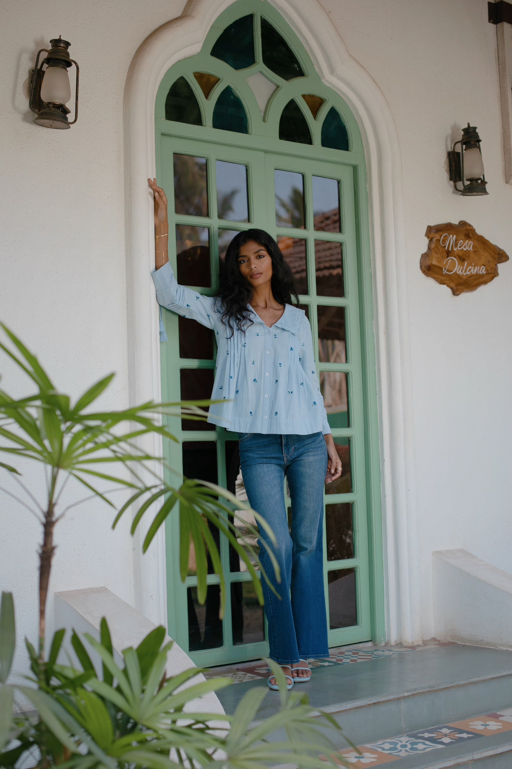 Front view of Light blue embroidered cotton linen boho blouse with peter pan oversized collar and tassel on sleeves — styled | Amaya World