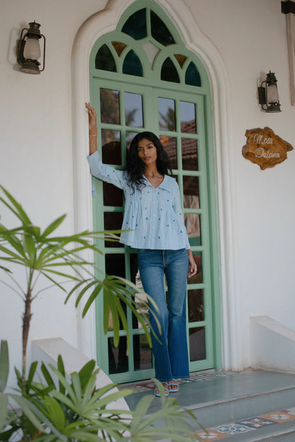 Front view of Light blue embroidered cotton linen boho blouse with peter pan oversized collar and tassel on sleeves — styled | Amaya World