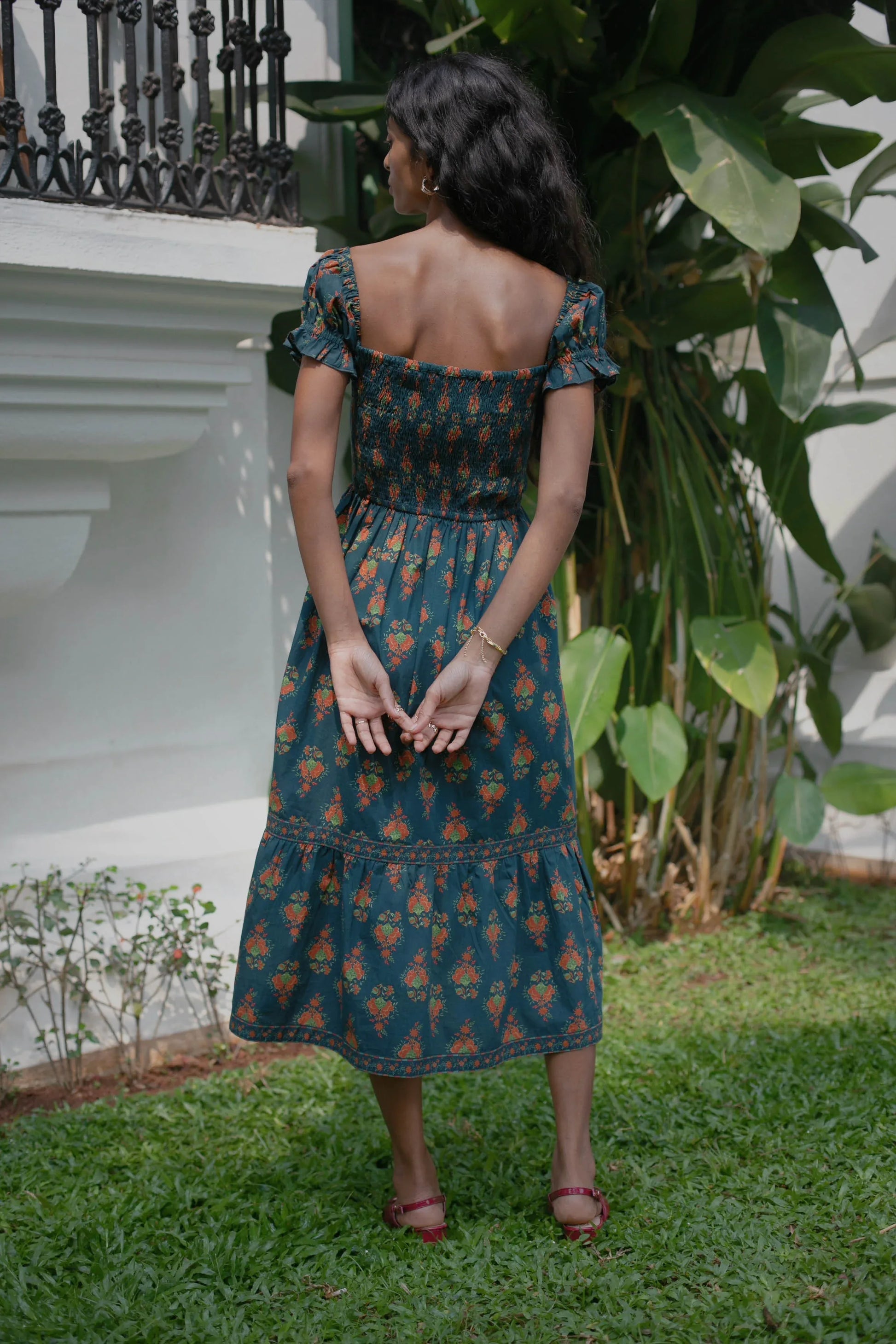 Back view of navy Chintz floral midi dress showing smocked bodice and elasticated fit — Amaya World