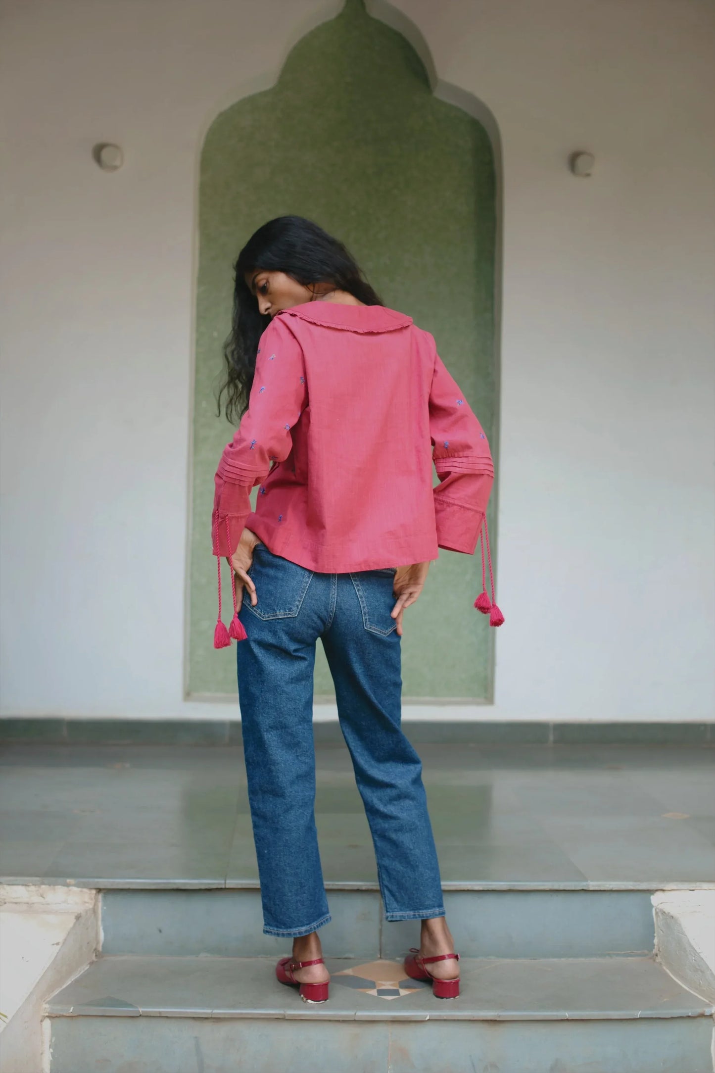 Back view of Red embroidered cotton linen boho blouse with oversized collar and tassel on sleeves — Amaya World