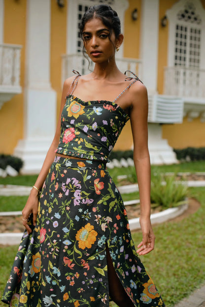 Close-up of floral botanical print on black high-waist A-line cotton poplin midi skirt styled with black floral crop top with sweetheart neckline and tie-up straps— Amaya World