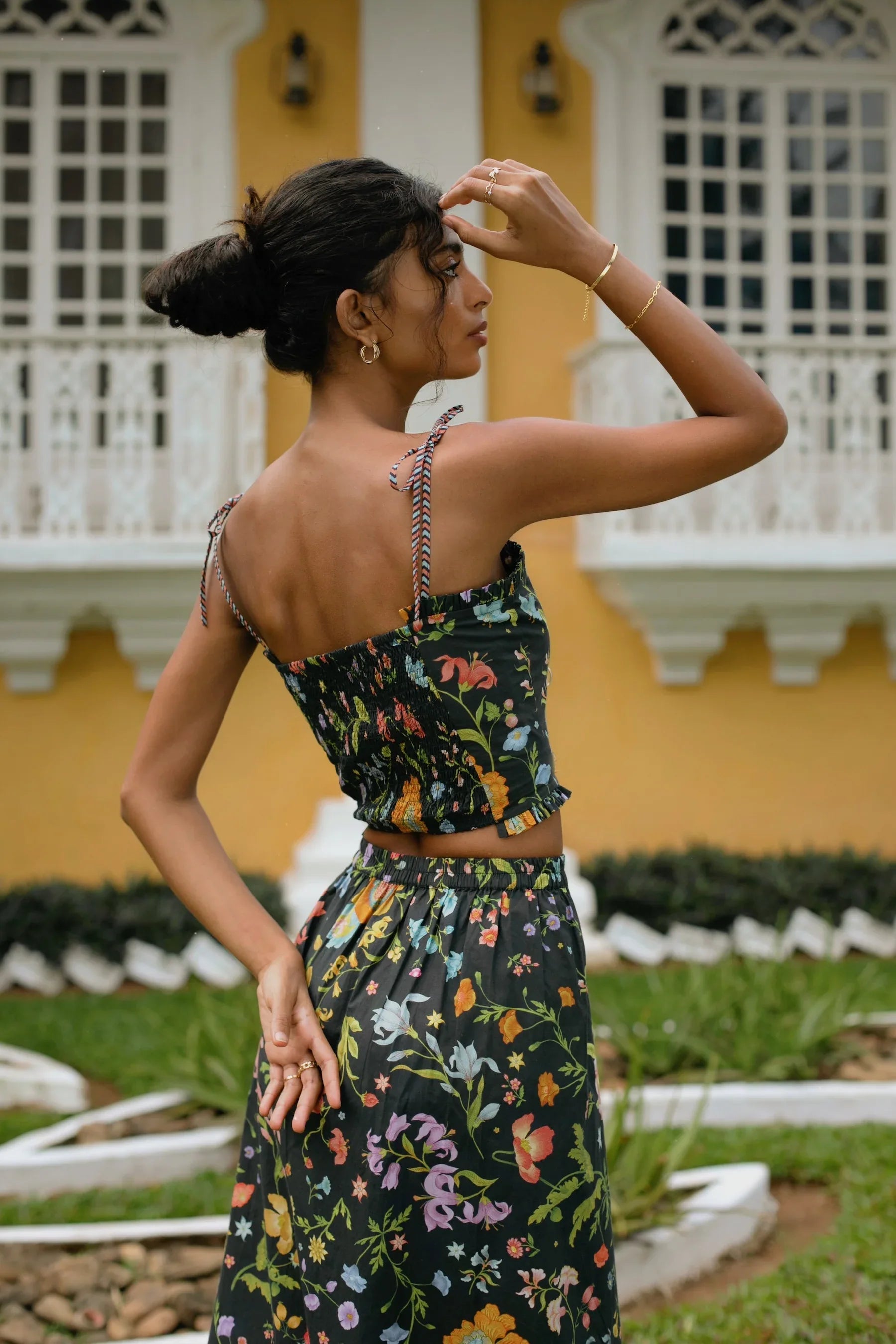 Back view of black floral midi skirt showing elasticated back and side zip paired with black floral crop top with elasticated back— Amaya World