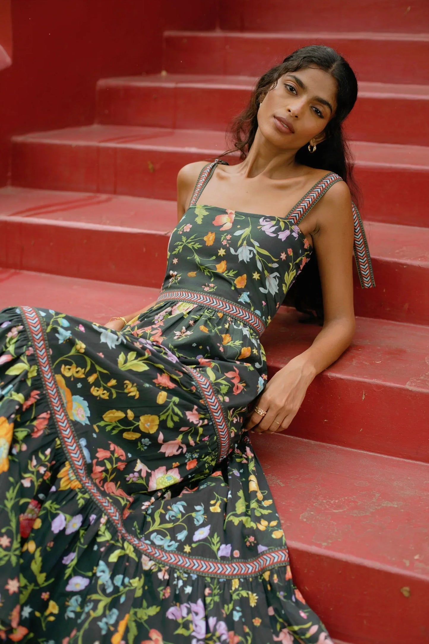 Close up view of Black floral tiered cotton maxi sundress with tie-up straps and fit-and-flare silhouette — Black wedding guest dress - Amaya World