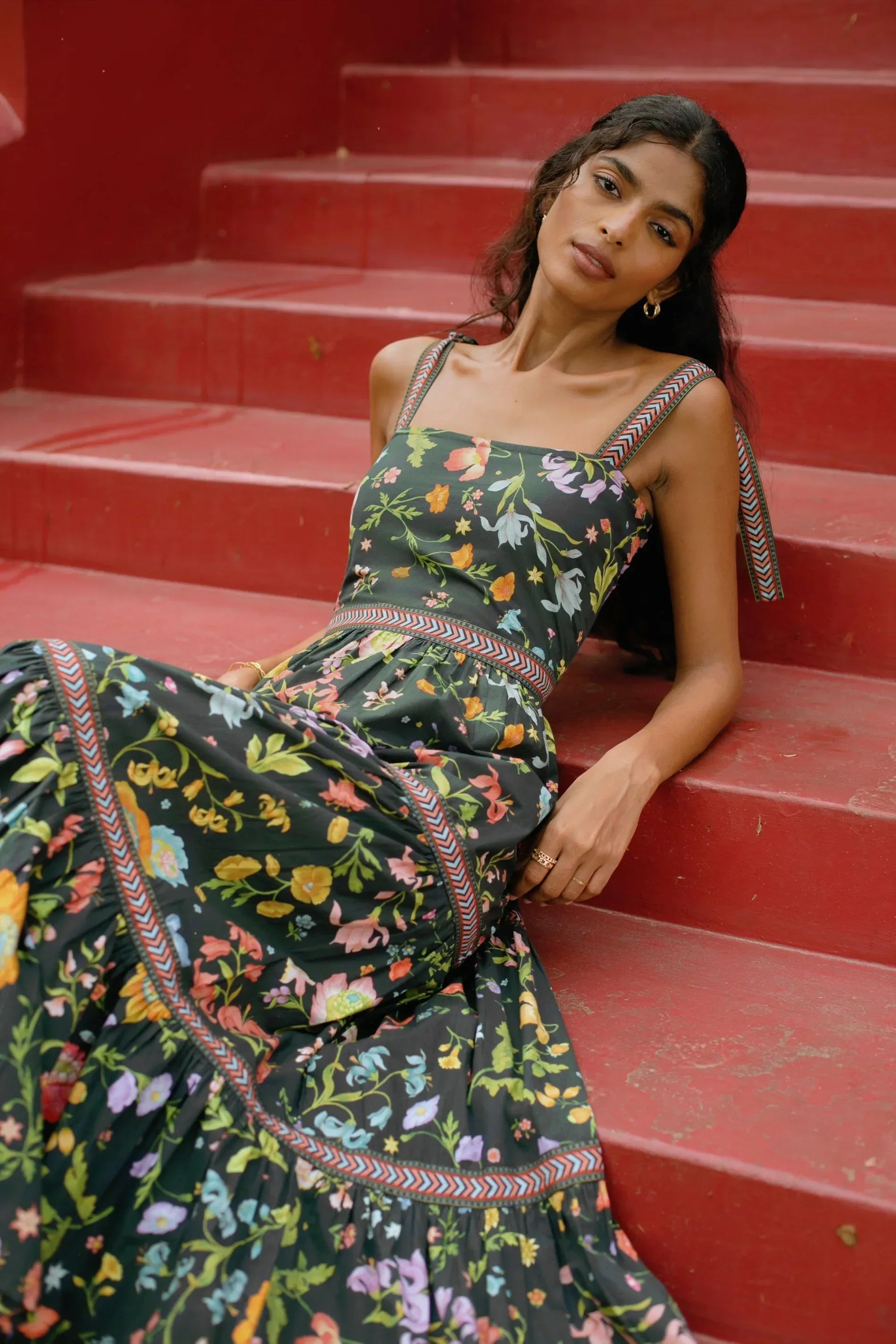 Close up view of Black floral tiered cotton maxi sundress with tie-up straps and fit-and-flare silhouette — Black wedding guest dress - Amaya World
