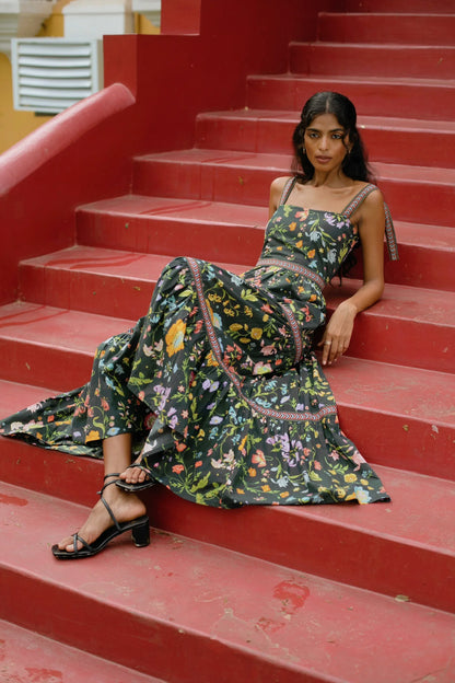 Side view of Black floral tiered cotton maxi sundress with tie-up straps and fit-and-flare silhouette — Black wedding guest dress - Amaya World
