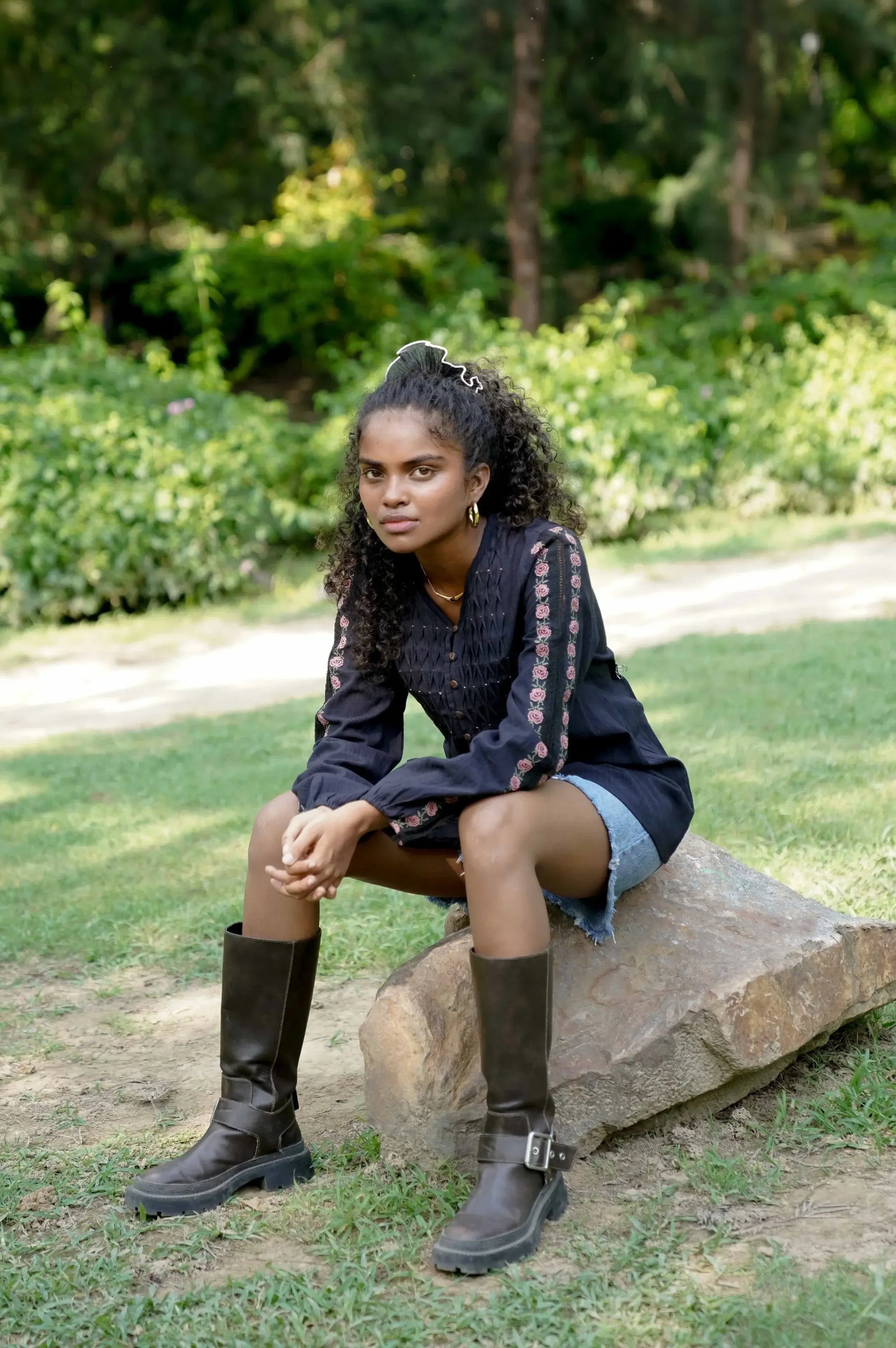 Lifestyle picture of black embroidered long sleeve cotton top styled with shorts and boots