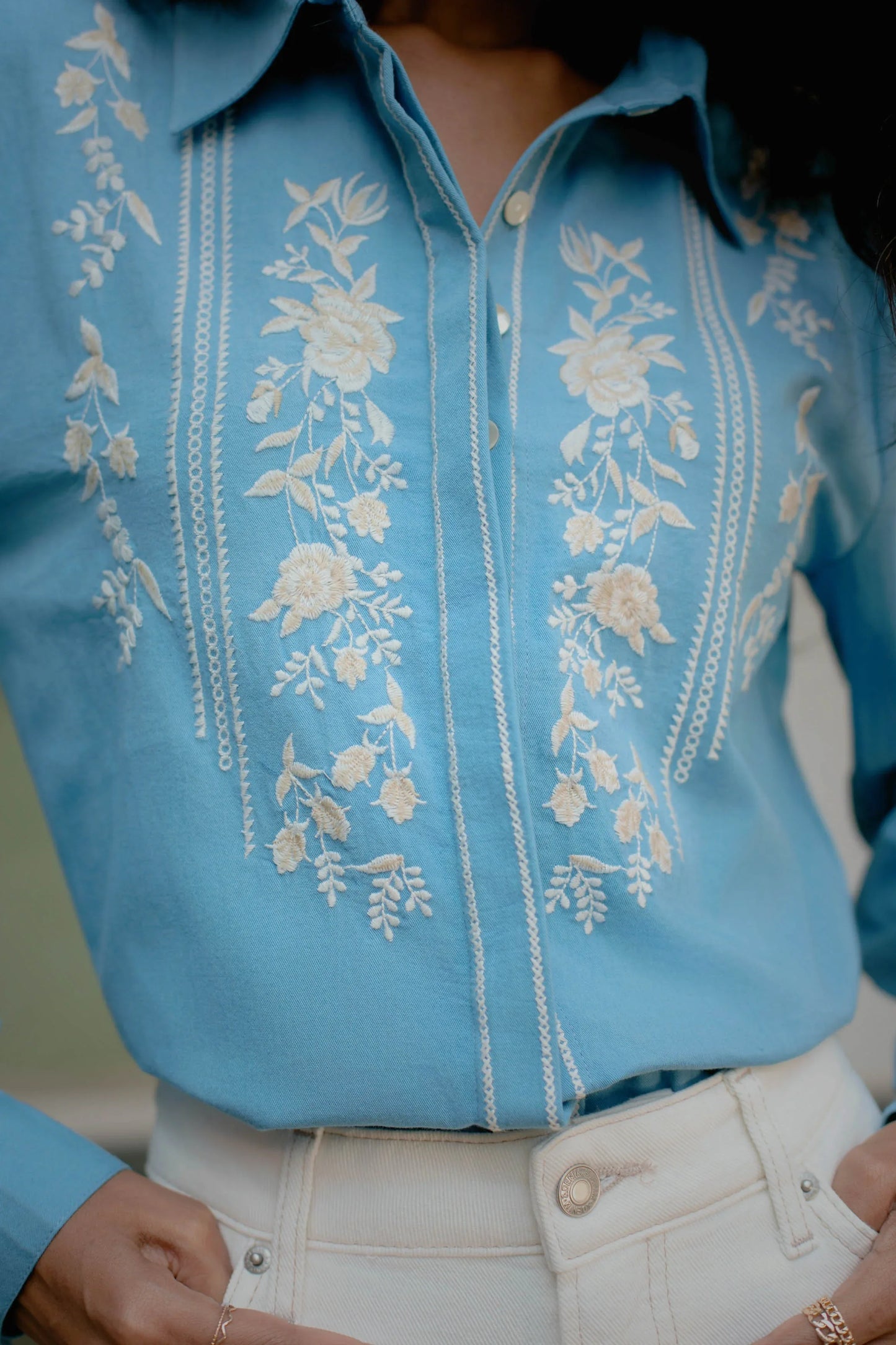 Close-up of white thread floral embroidery on blue cotton button-down shirt — Amaya World slow fashion