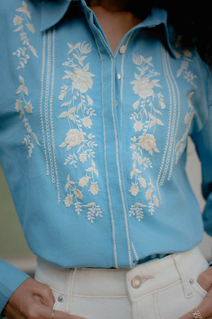 Close-up of white thread floral embroidery on blue cotton button-down shirt — Amaya World slow fashion