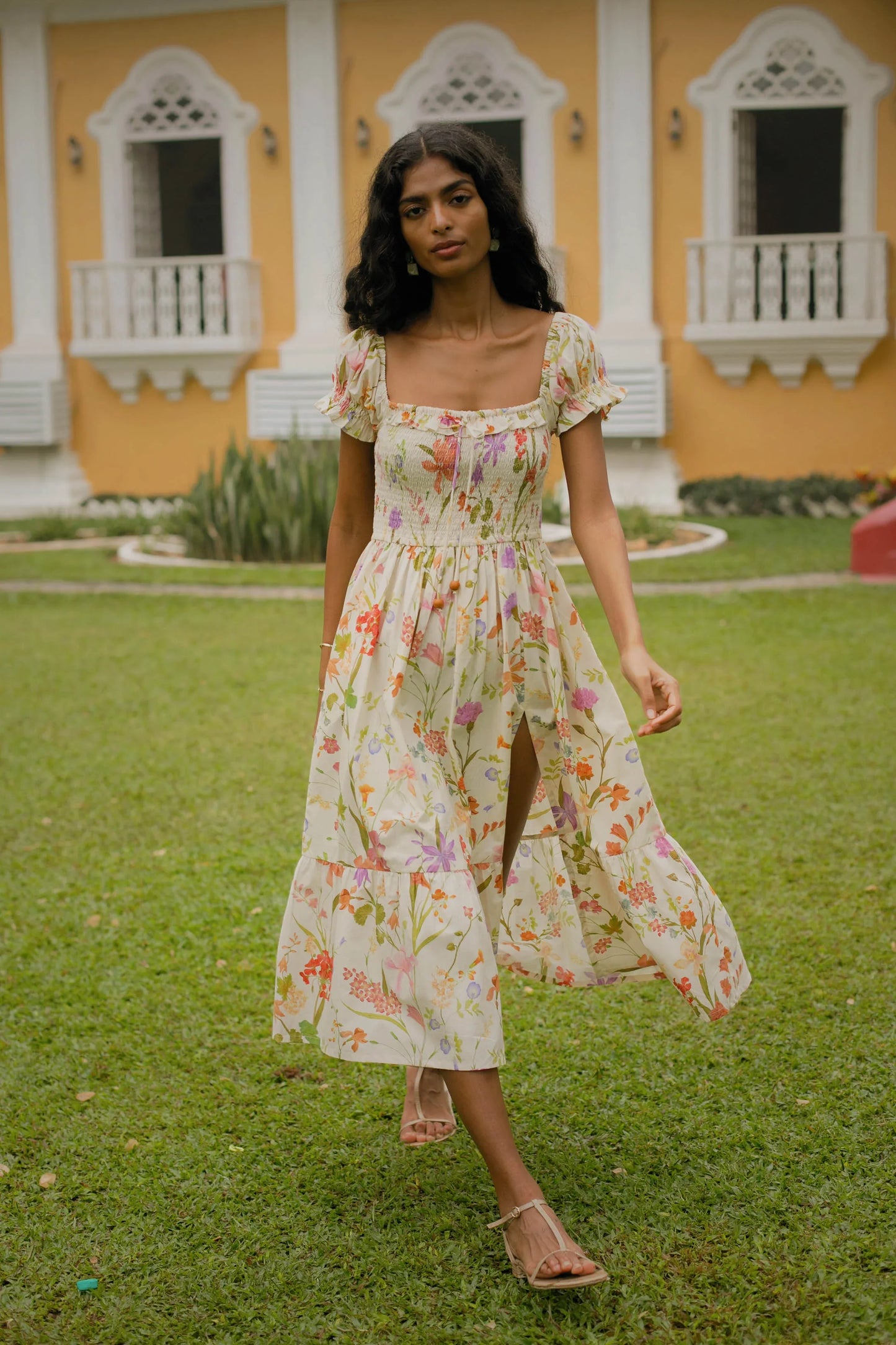 Cream floral cotton midi dress showing puff sleeves, side slit and fit-and-flare silhouette — Amaya World