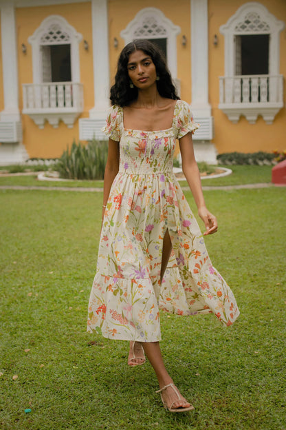 Cream floral cotton midi dress showing puff sleeves, side slit and fit-and-flare silhouette — Amaya World