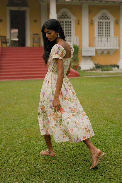 Back view of cream floral midi dress showing smocked bodice, puff sleeves and elasticated fit — Amaya World
