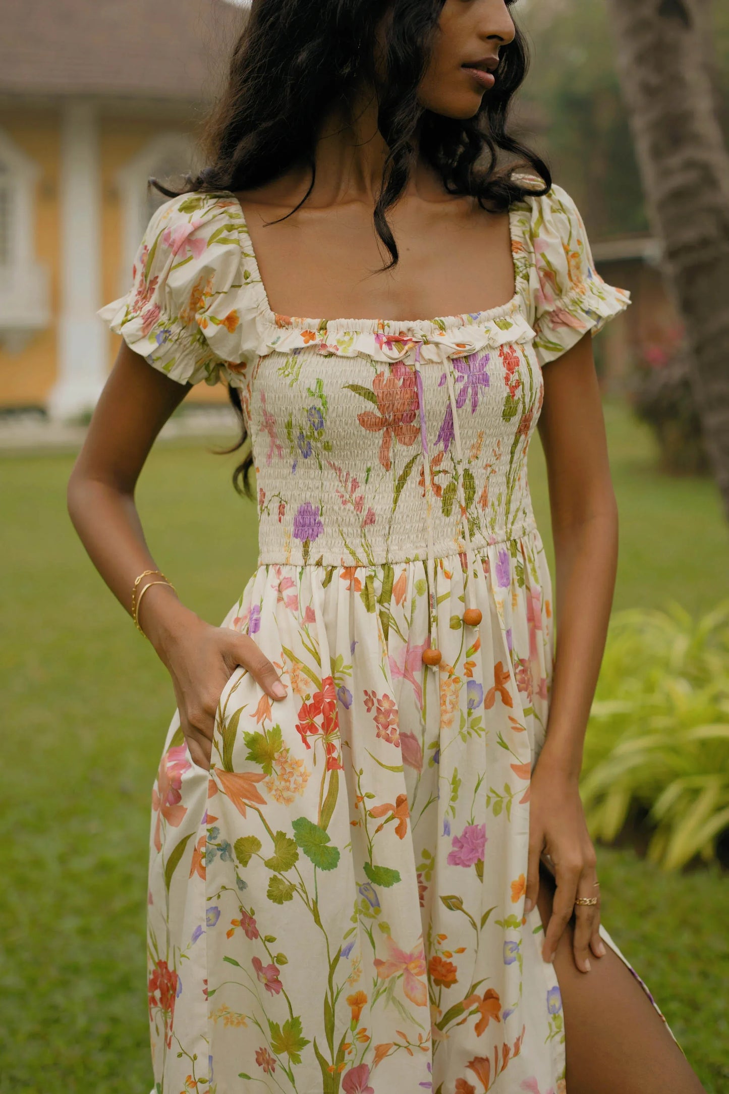 Close-up of smocked bodice and handmade tassels on cream floral cotton midi dress — Amaya World