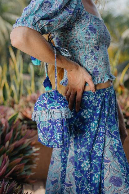 side picture of model wearing indigo bucket bag