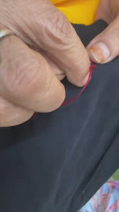 video of artist doing hand embroidery on on black embroidered camisole