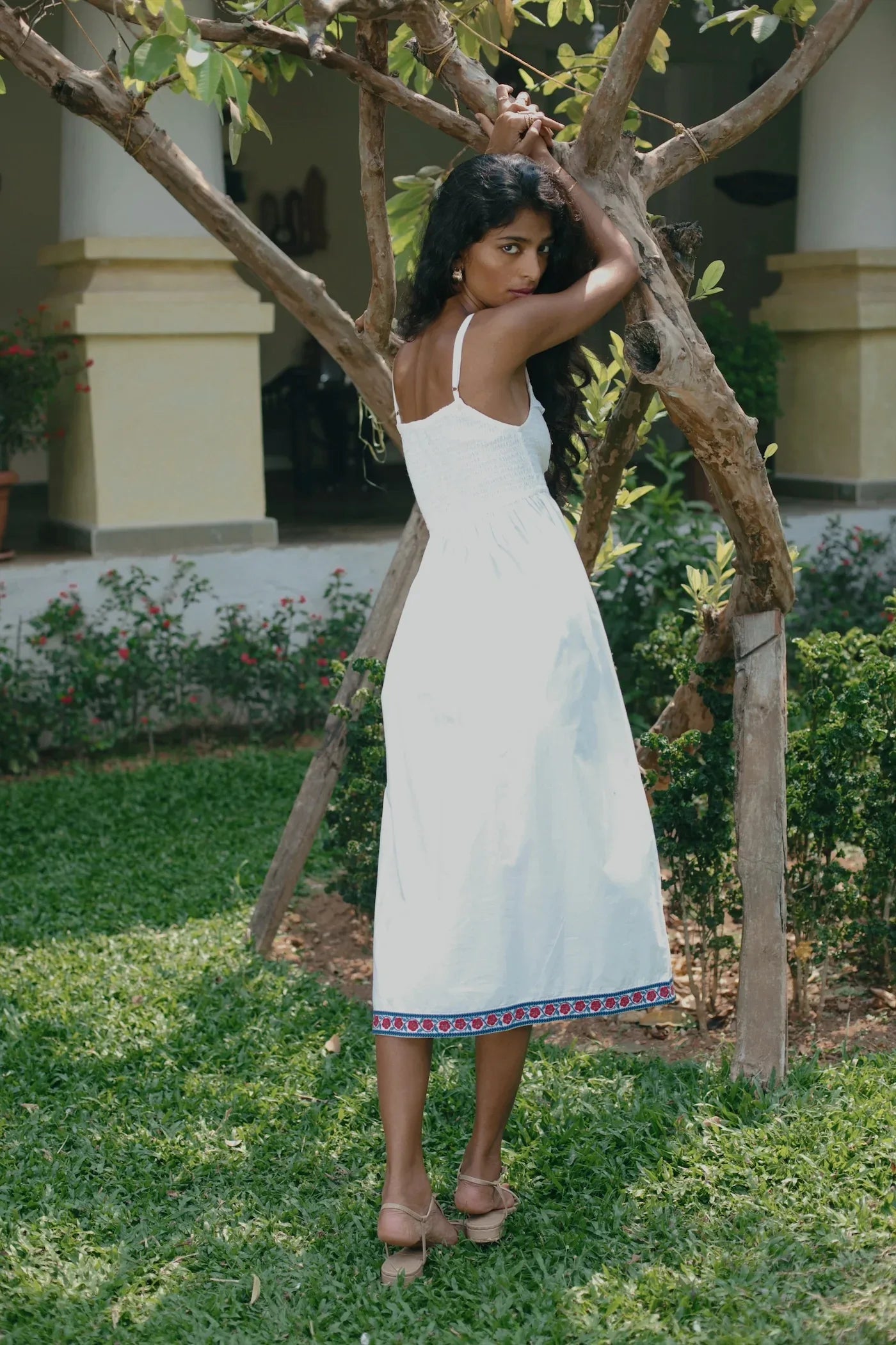 Back view of white embroidered cotton poplin midi dress showing elasticated back and adjustable straps — Amaya World