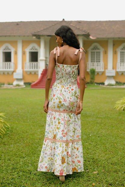 Back view of white floral tiered cotton maxi sundress with tie-up straps and A-line silhouette showing elasticated back— Amaya World